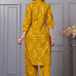 Back view of the ochre yellow straight fit floral cotton kurta set showcasing the fit of the trousers and the falling pattern of the printed dupatta