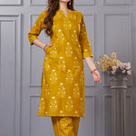 Side profile view of a model in the ochre yellow floral printed cotton salwar suit showcasing the elegant side slit and chevron trousers