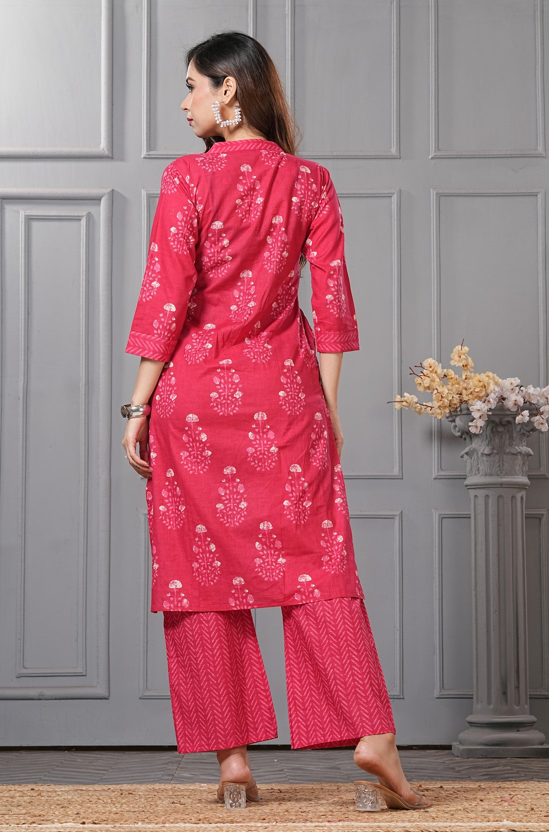Back view of the rani pink straight fit floral cotton kurta set highlighting the print continuation and the dupatta drape