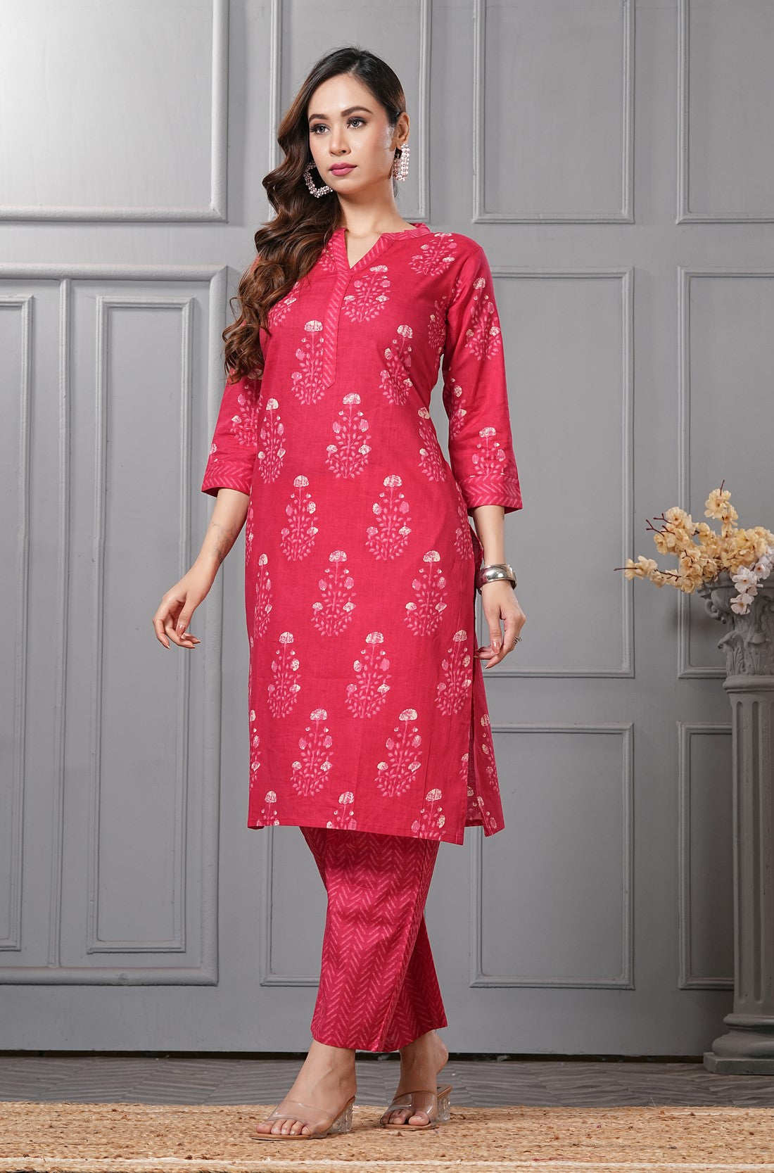 Side profile view of a model in the rani pink floral printed cotton ethnic suit showcasing the clean straight-cut drape and chevron print trousers