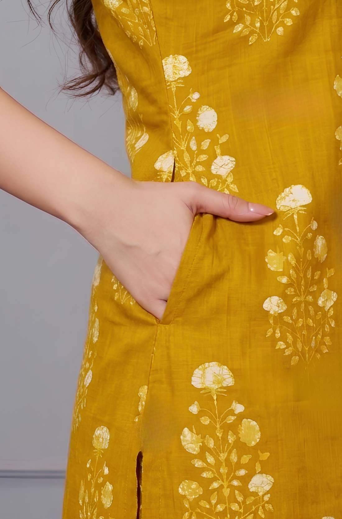 Macro close-up highlighting the clean tailoring and side pocket design on a teal floral printed cotton kurta, showcasing the intersection of the side slit and the pocket opening.