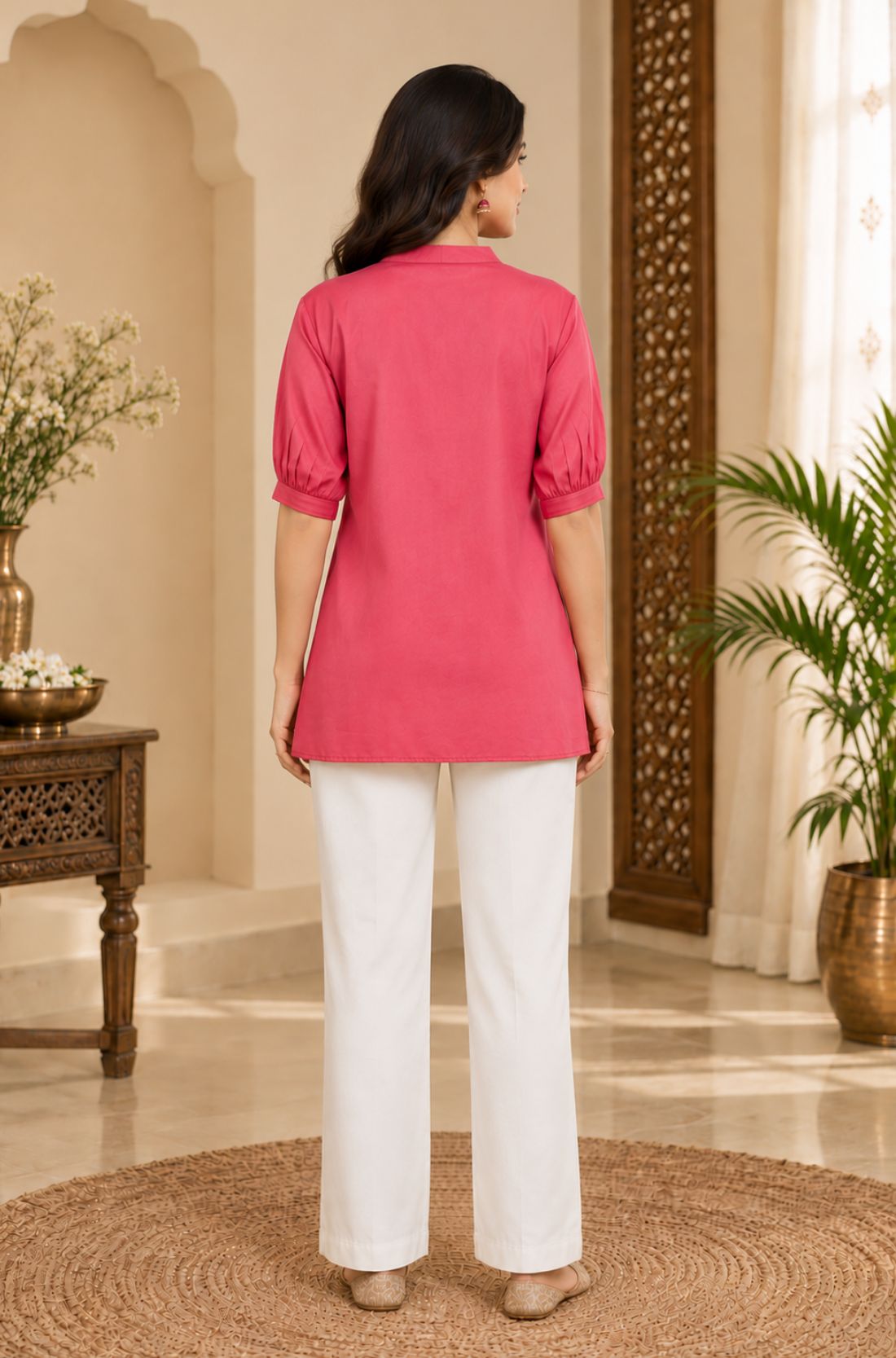 Full-length back view of a woman wearing the dark peach rayon top with white trousers.