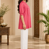 Full-length side profile view of a model showcasing the fit and puff sleeves of the dark peach rayon pleated top.