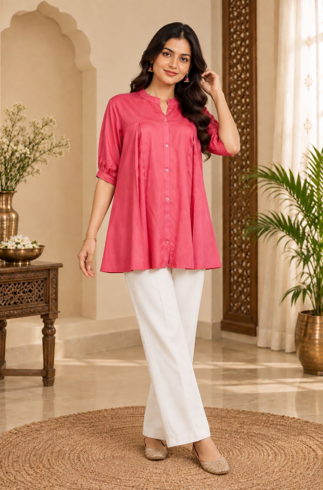 Full-length angled view of a model posing in a dark peach pleated rayon tunic with elbow-length sleeves.