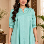Close-up shot showing the collar, front button placket, and pleated details of the light sea green rayon top.
