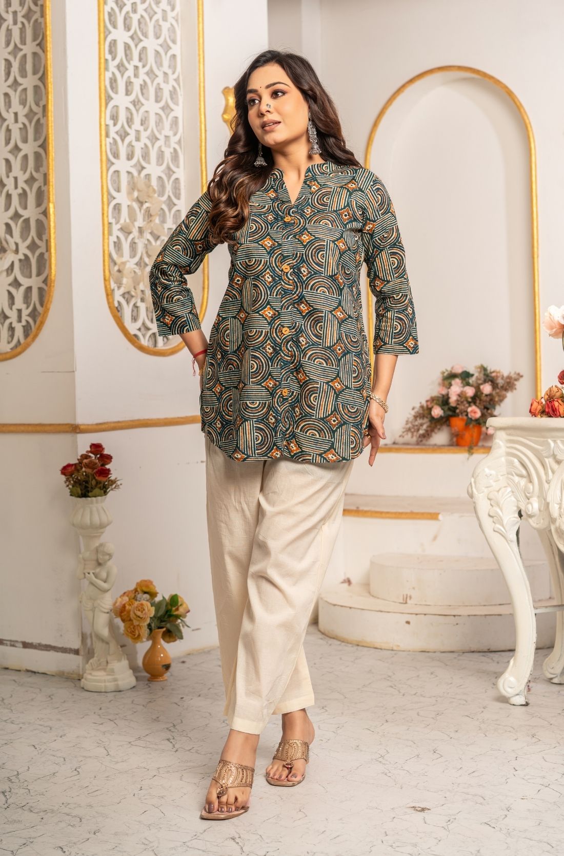 Women's Geometric Hand Block Print Pure Cotton Shirt Style Kurti in forest green and rust orange featuring a stand collar, wooden button placket, 3/4 sleeves, and a relaxed hip-covering silhouette paired with linen trousers.