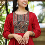 Close-up view of a woman wearing a maroon rayon round-neck kurta showcasing detailed mirror work and block-printed yoke embroidery