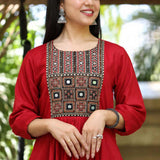 Close-up view of a woman wearing a maroon rayon round-neck kurta showcasing detailed mirror work and block-printed yoke embroidery