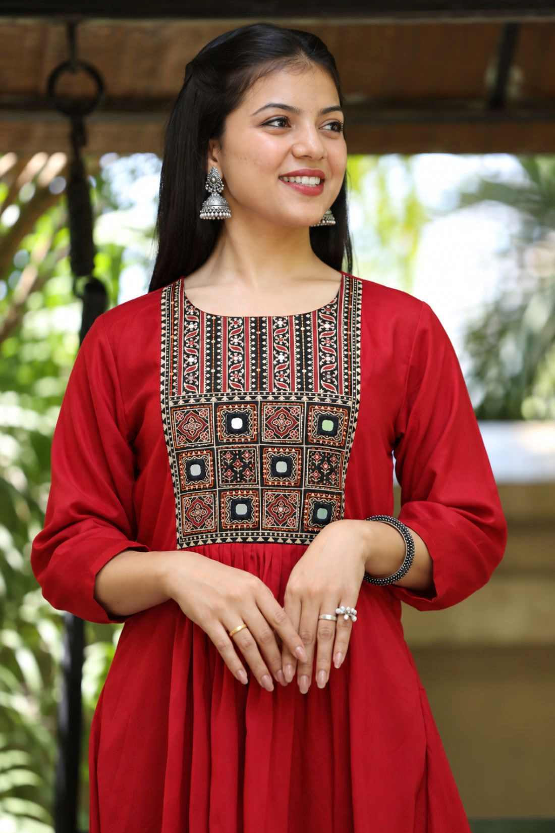 Close-up view of a woman wearing a maroon rayon round-neck kurta showcasing detailed mirror work and block-printed yoke embroidery