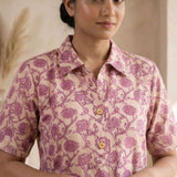 Front close-up of a women's blush pink floral block print cotton shirt featuring wooden buttons and collared neckline.