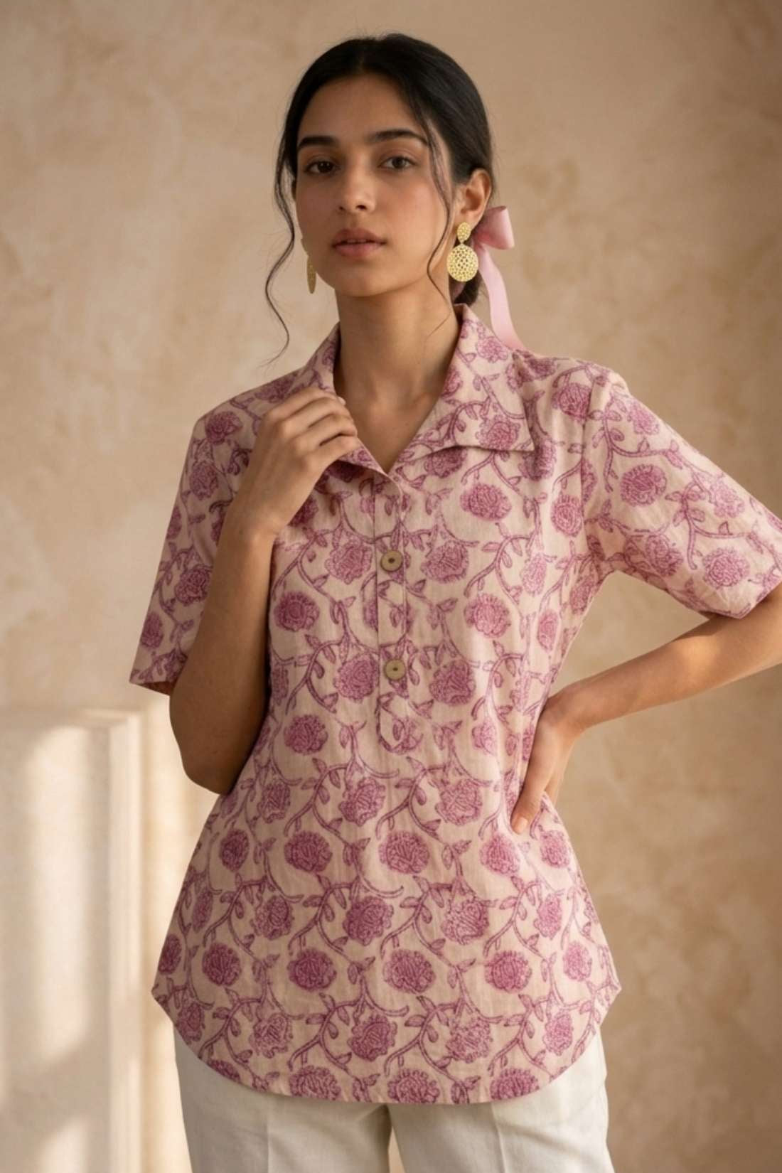 Front close-up of a women's blush pink floral block print cotton shirt featuring wooden buttons and collared neckline.