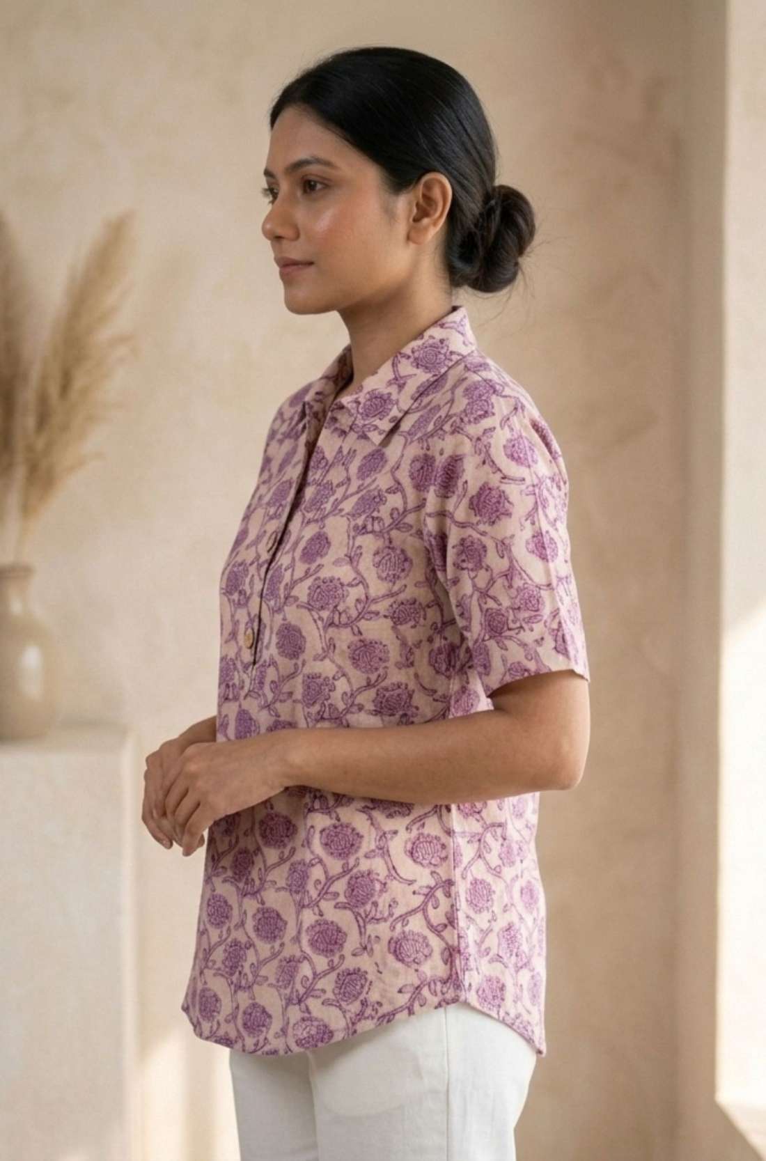 Side profile of a women's blush pink floral block print cotton shirt with relaxed fit and classic collar.