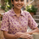 Women's blush pink floral hand block print cotton shirt styled casually while seated at an outdoor café.