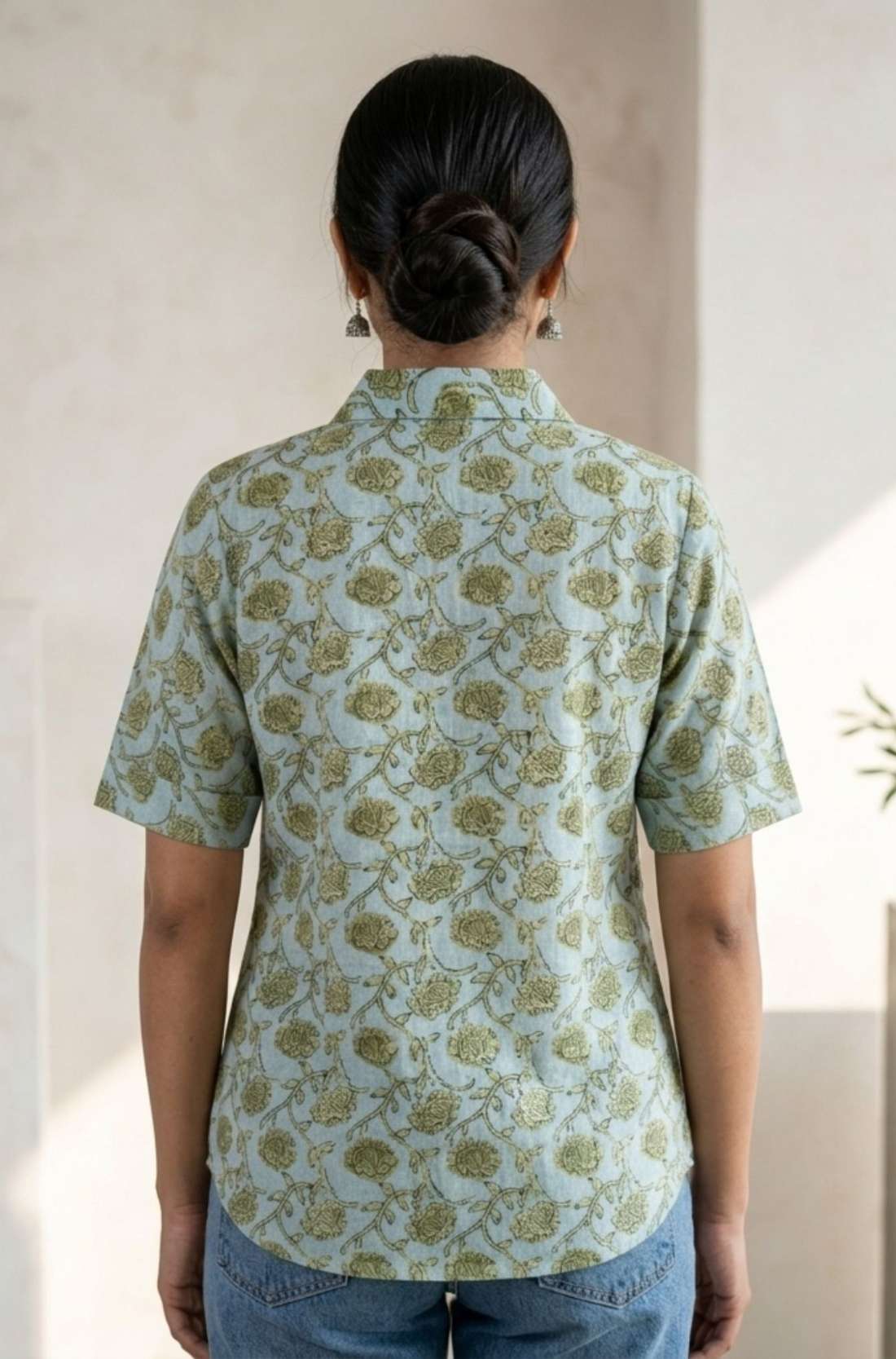 Back View
Back view of a women's mint green block print cotton shirt featuring short sleeves and curved hem.