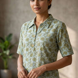 Front close-up of a women's mint green floral block print cotton shirt with wooden buttons and classic collar.