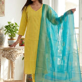 A smiling woman sitting on a white chair wearing a stylish yellow pure cotton thread embroidered kurta set with a matching printed dupatta