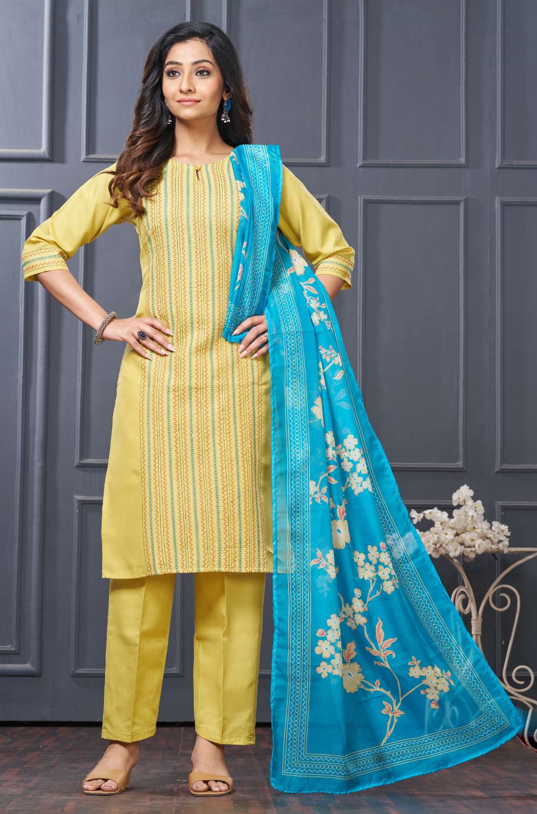 Profile view of a model in a yellow cotton ethnic kurta set displaying the straight-cut pants silhouette and the beautiful pattern of the draped matching dupatta